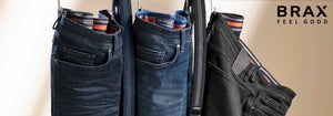 Three pairs of jeans hanging on a clothes hanger