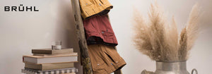 Three pairs of trousers folded over a ladder shelf