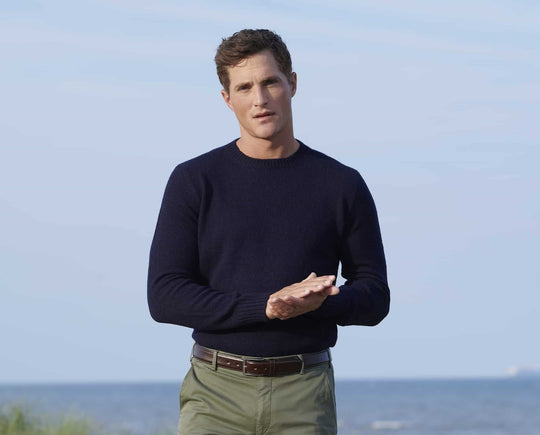 Man wearing a dark blue knitwear and green trousers